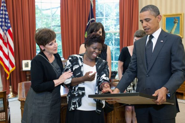 Lois Curtis hands a painting to President Barack Obama in the Oval Office